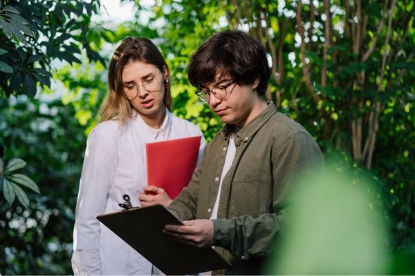 Chuyên viên môi trường trao đổi tài liệu trong quá trình khảo sát và đánh giá tác động môi trường tại thực địa.
